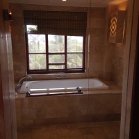 A shower and separate tub with a door that led out to the balcony.